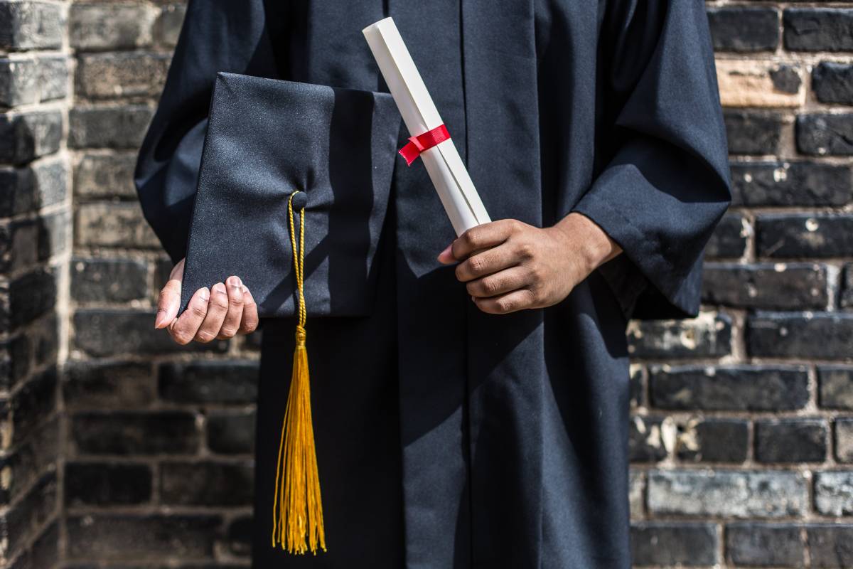 Graduate holding cap and diploma