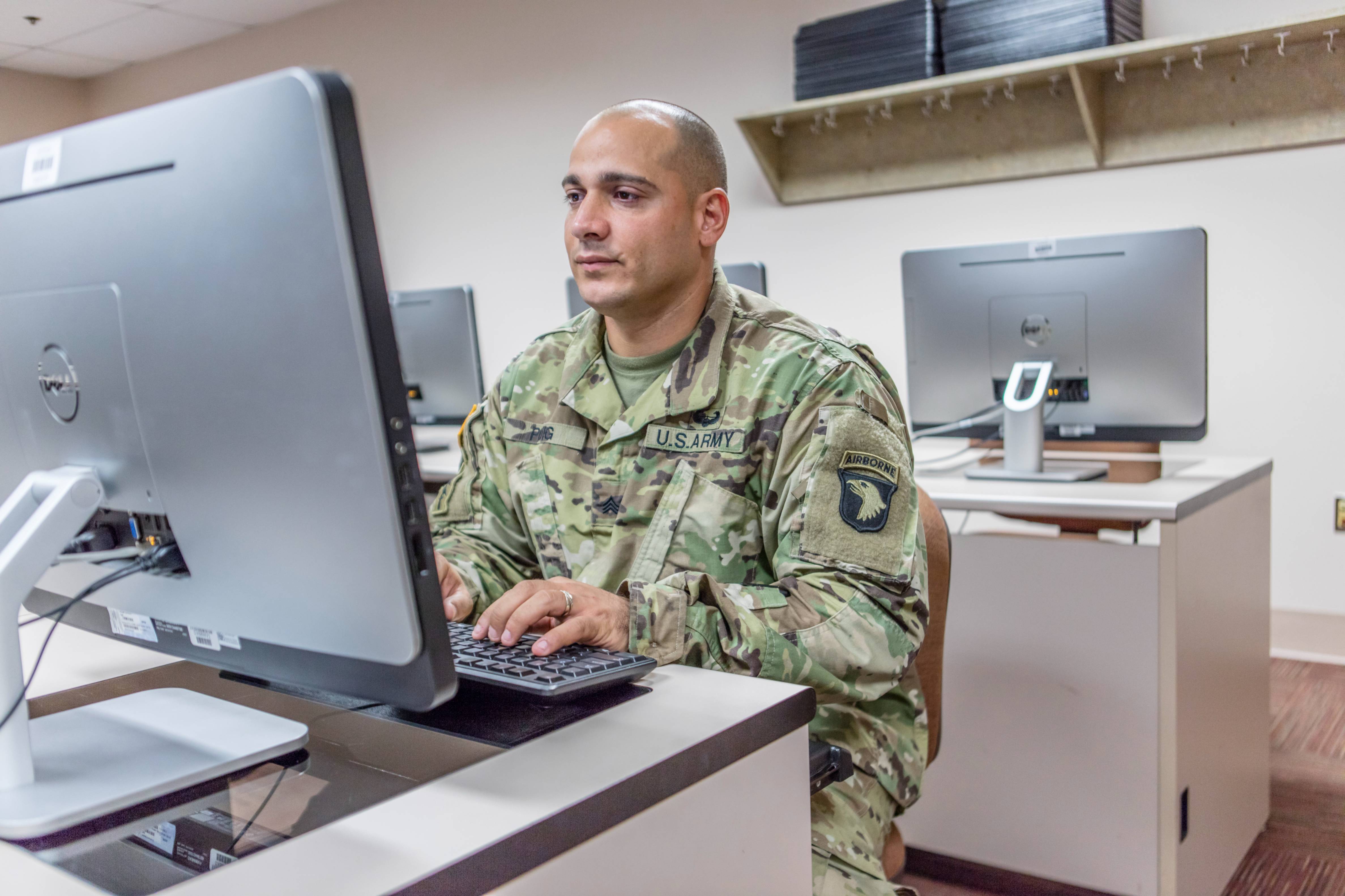 Man in army fatigues sitting at computer