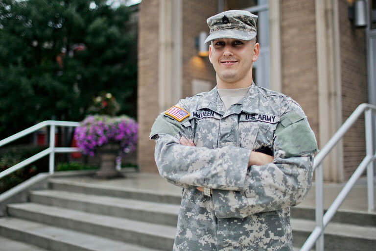 Soldier standing on stairs with arms crossed