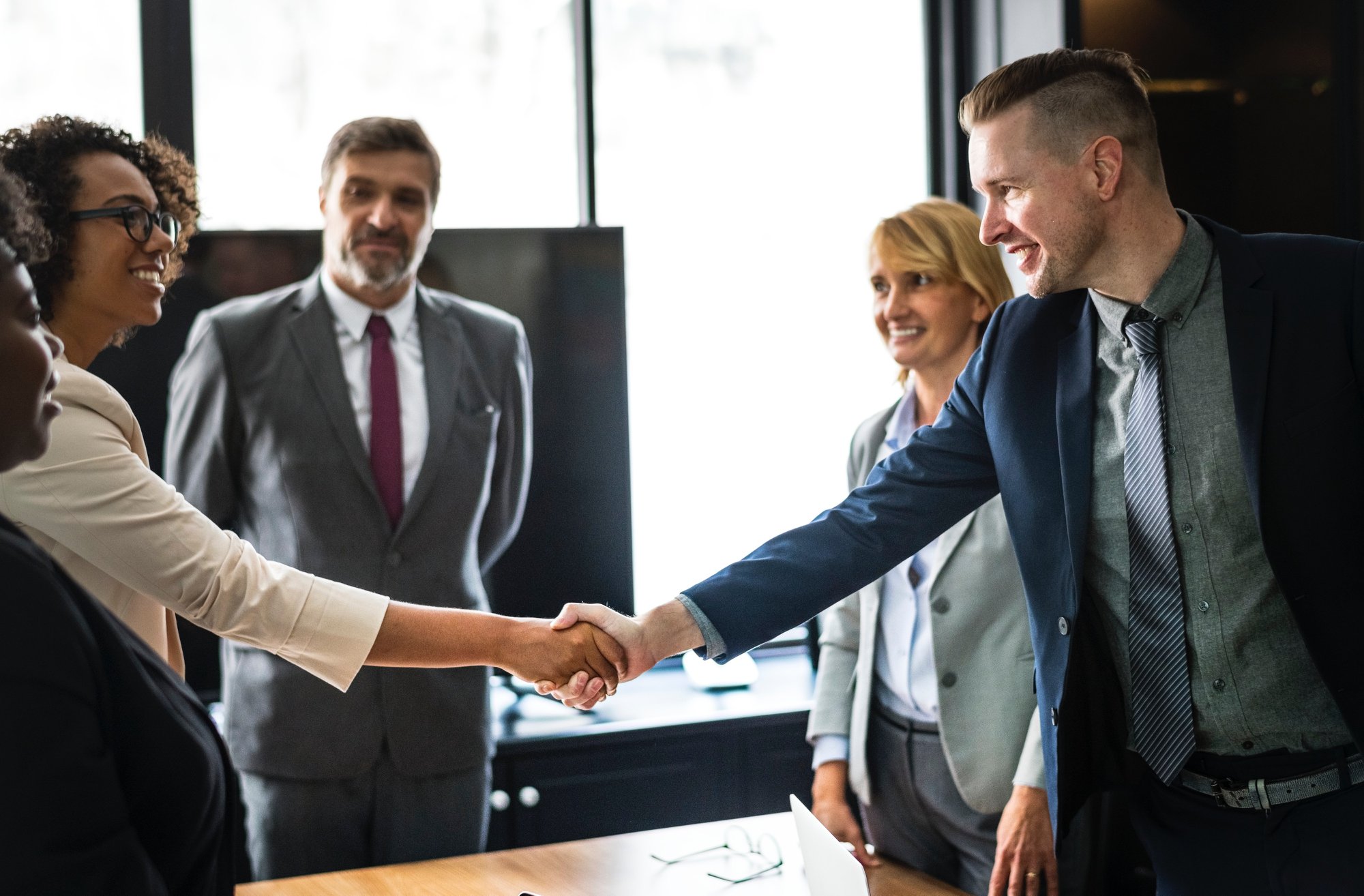 people shaking hands in conference room.